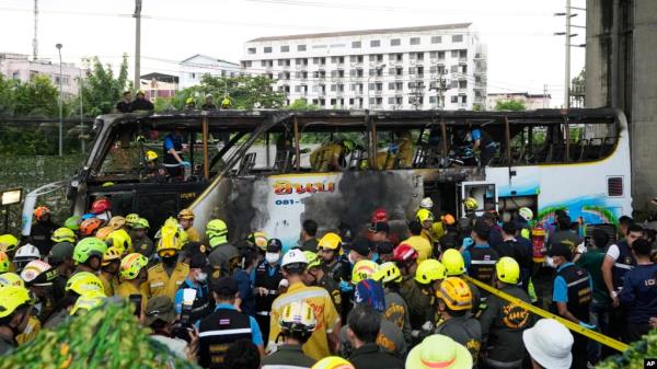 Rescuers inspect a bus that caught fire as it was carrying young students with their teachers, in suburban Bangkok, Oct. 1, 2024. 