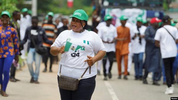 A woman waves a flag while participating in an Independence Day celebration in Abuja, Nigeria, Oct. 1, 2024. 