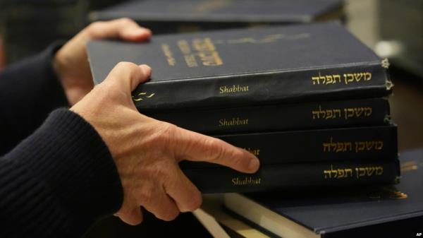 Craig Berko, director of membership at Temple Beth Sholom, prepares to hand out prayer books during a Shabbat service, Sept. 27, 2024, in Miami Beach, Fla.