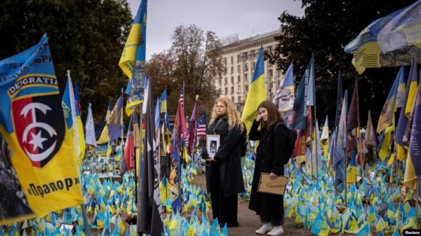 Women hold portraits of loved o<em></em>nes who were killed fighting amid Russia's invasion of Ukraine, at a memorial site for fallen Ukrainian soldiers as the country marks Defenders of Ukraine Day, in Kyiv, Oct. 1, 2024. 