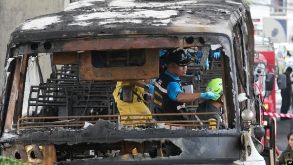 Officers of a police forensics team inspect a bus that caught fire, carrying young students with their teachers, in suburban Bangkok, Oct. 1, 2024.