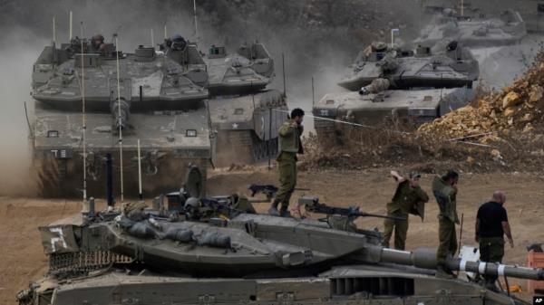 Israeli army tanks maneuver in a staging area in northern Israel near the Israel-Lebanon border, Oct. 1, 2024.