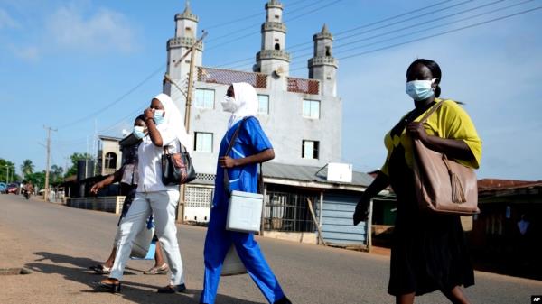 FILE - Health workers arrive to administer cervical cancer vaccine HPV Gardasil to young girls on the street in Ibadan, Nigeria, May 27, 2024. The World Health Organization estimates that 80% of childhood cancers occur in low-income countries like Nigeria,