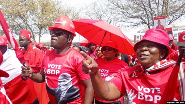 Botswana Democratic Party supporters wearing shirts displaying the portrait of President Mokgweetsi Masisi dance outside the High Court of Botswana in Gaborone, Sept, 28, 2024. 