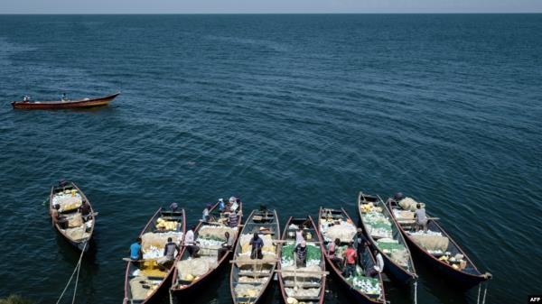 FILE - Fishermen prepare their nets aboard their boats on Migingo island, which is densely populated by residents fishing mainly for Nile perch in Lake Victoria on the border of Uganda and Kenya, on Oct. 5, 2018. 