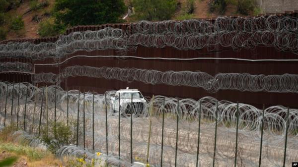 FILE - A vehicle drives along the U.S. side of the US-Mexico border wall in Nogales, Arizona, June 25, 2024.