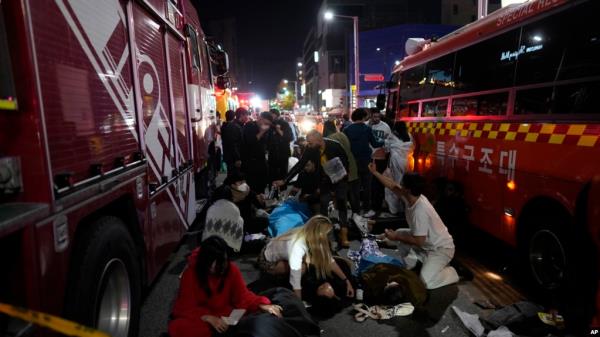 FILE - Injured people are helped at a street near the scene of a crush in Seoul, South Korea, on Oct. 30, 2022. 