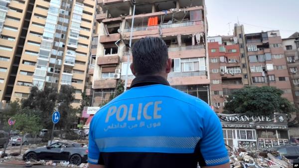 A Lebanese police officer looks at damaged apartments that were hit by Israeli strike early Sept. 30, 2024. 