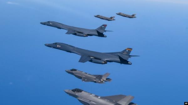 FILE - In this photo provided by South Korea Defense Ministry, U.S. Air Force B-1B bombers, center, fly in formation with South Korea's Air Force F-35A fighter jets over the South Korea Peninsula during a joint air drill in South Korea, March 19, 2023.