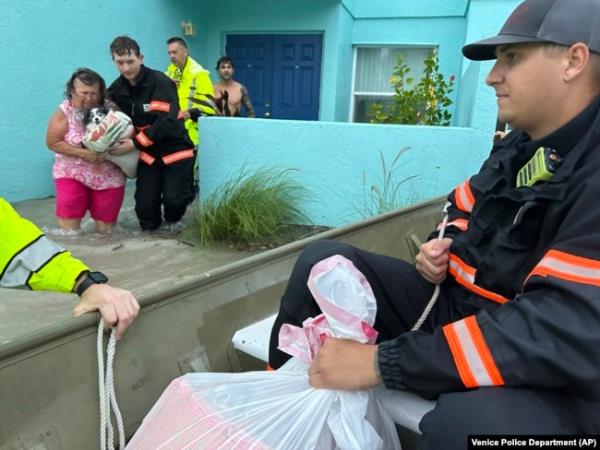 This photo provided by Venice Police Department rescue crews assist residents after co<em></em>nducting door-to-door wellness checks, in coastal areas flooded by Hurricane Helene on Sept. 27, 2024 in Venice, Florida. (Venice Police Department via AP)