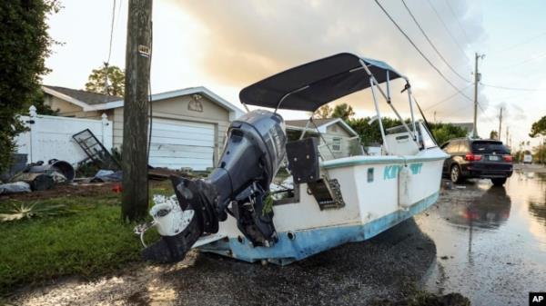 A boat rests on a street after being relocated during flooding caused by Hurricane Helene, Sept. 27, 2024, in Hudson, Florida.