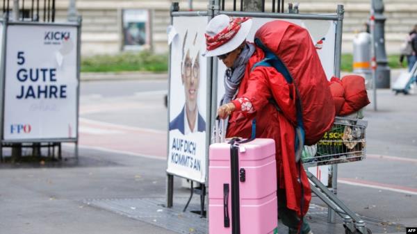 A homeless woman walks by damaged election campaign posters reading '5 Good Years' of the Freedom Party of Austria (FPOe) in Vienna, Austria, on Sept. 28, 2024. General elections in Austria will take place on Sept. 29, 2024. 