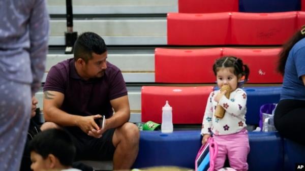 A man sits with his family inside a hurricane evacuation shelter at Fairview Middle School before Hurricane Helene made landfall in Leon County, Florida, Sept. 26, 2024.