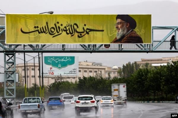 A banner bearing a picture of Lebanon's Hezbollah leader Hassan Nasrallah with writing in Farsi that reads 