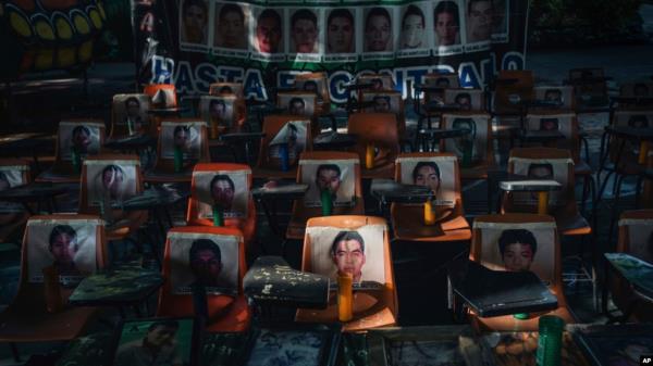 FILE - Photos of 43 students who have been missing for 10 years cover the stairs at their former Raúl Isidro Burgos Rural Normal School in Ayotzinapa, Guerrero state, Mexico, Aug. 24, 2024. 