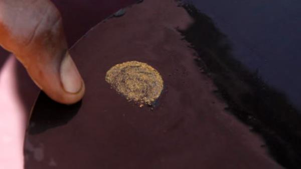 A prospector sorts gold particles found at gold mine in Walungu territory of South Kivu, Democratic Republic of the Congo, May 10, 2014. Photo: REUTERS/Kenny Katombe/File Photo