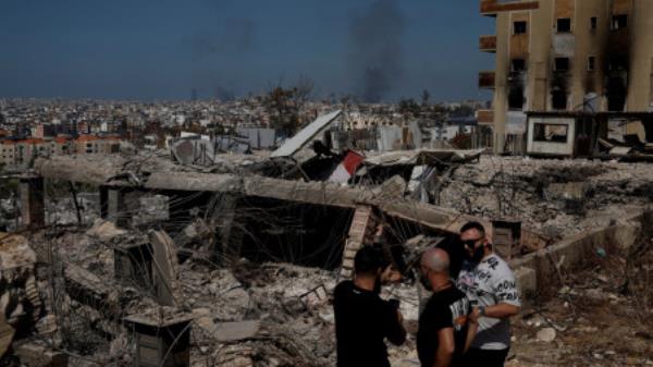  People stand amid damage caused by Israeli airstrikes, as smoke rises over Beirut southern suburbs, amid o<em></em>ngoing hostilities between Hezbollah and Israeli forces, in the Choueifat district, in Beirut, Lebanon, October 3, 2024. REUTERS/Louisa Gouliamaki/File Photo