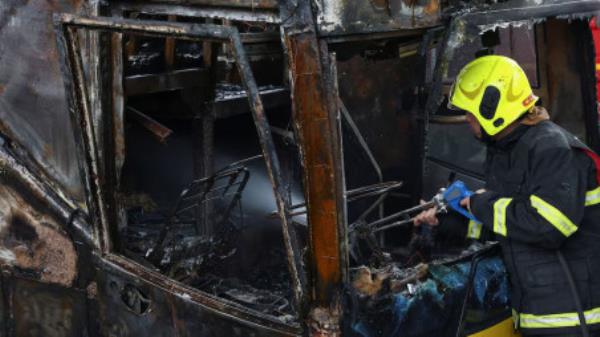 Firefighter works to extinguish a burning bus that was carrying teachers and students from Wat Khao Phraya school, reportedly killing almost a dozen, on the outskirts of Bangkok, Thailand, October 1, 2024. REUTERS/Chalinee Thirasupa