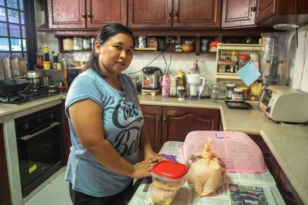 In Singapore, an Indo<em></em>nesian domestic worker prepares food in her employer’s kitchen after an early morning trip to the grocery store (file).