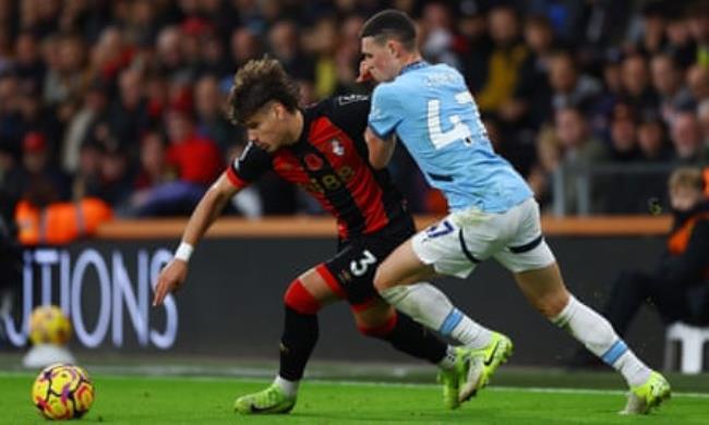 Bournemouth’s Milos Kerkez (left) gets the better of Manchester City’s Phil Foden